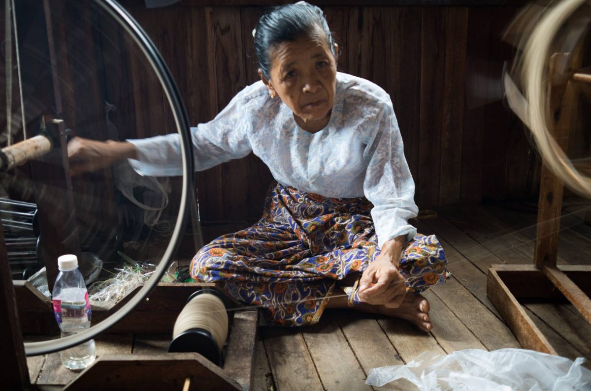 A woman at her loom weaving fibres from Lotus plants